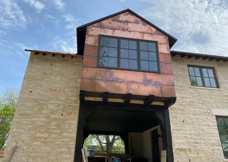 Copper metal panel facade on a stone building for Skylight Installation in Laketown