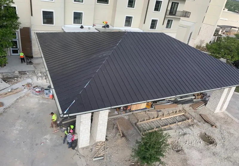 Metal roofing installation team working on a commercial building in Laketown